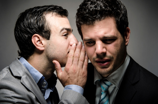 image of a young professional whispering to another