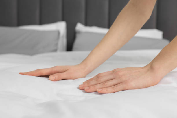 istock Young woman making bed in room, closeup 1743425112