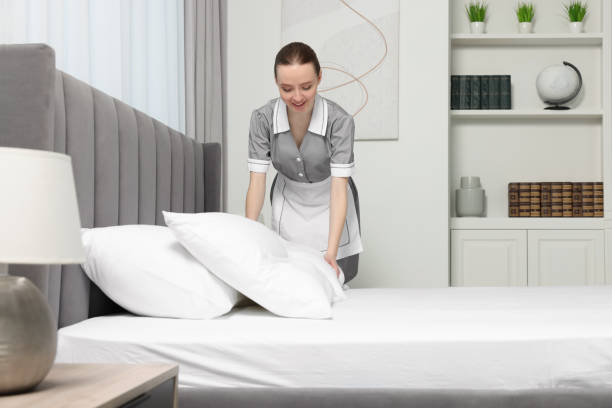 istock Young maid making bed in hotel room 1743428138