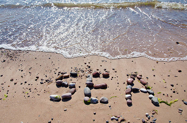 istock word sea concept on beach sand and waves 174345640