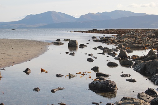 Stream flowing out to sea from the west coast of Bute with the island of Arran in the distance.
