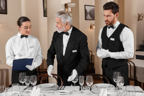 istock Senior man wearing formal suit teaching trainees in restaurant. Professional butler courses 1743493977