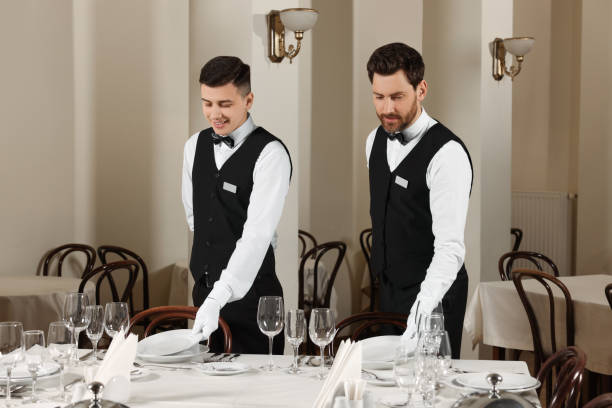 homens colocando mesa no restaurante. cursos de mordomo profissional - restaurant business person setting the table clothing - fotografias e filmes do acervo