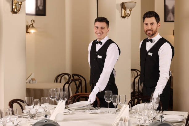 istock Men setting table in restaurant. Professional butler courses 1743497227
