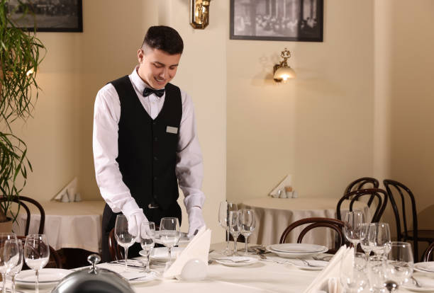 istock Man setting table in restaurant. Professional butler courses 1743497243