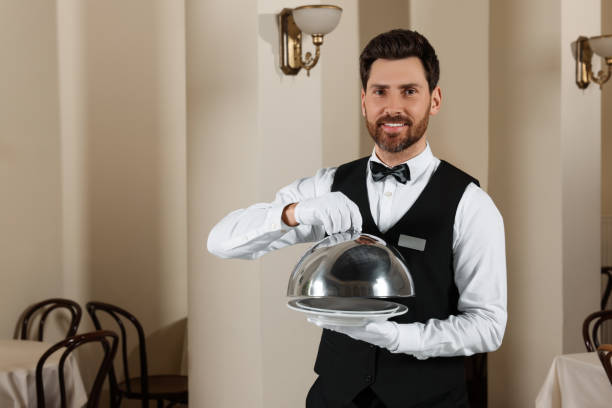 istock Man setting table in restaurant. Professional butler courses 1743497246