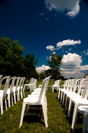 White, plastic chairs arranged outdoors. .