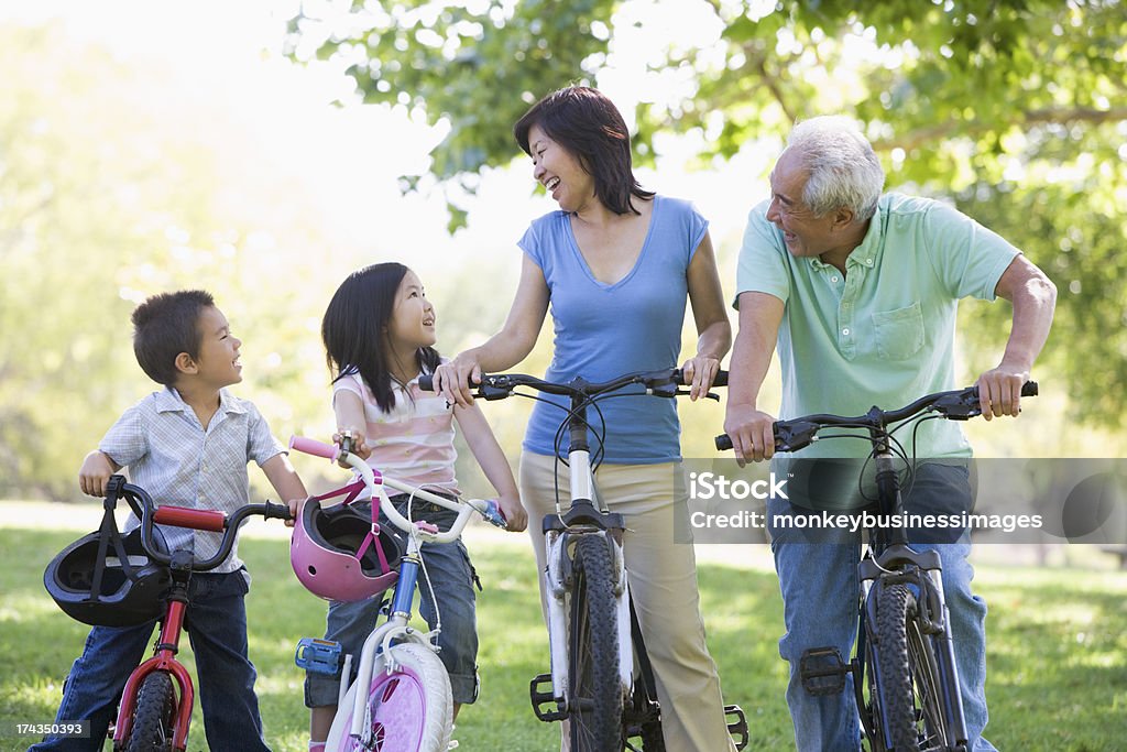 Grandparents bike riding with grandchildren Grandparents bike riding with grandchildren smiling to each other Japanese Ethnicity Stock Photo