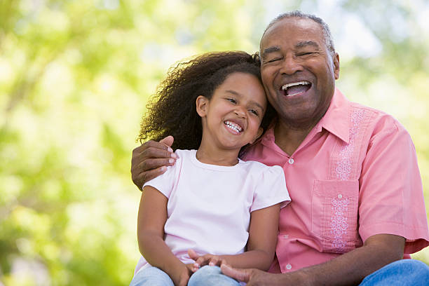 Grandfather and granddaughter outdoor portrait Grandfather and granddaughter outdoors smiling and laughing granddaughter stock pictures, royalty-free photos & images