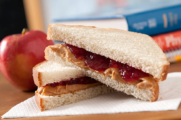 Peanut Butter and Jelly Sandwich Peanut butter and jelly sandwich with a apple in a classroom.  Please see my portfolio for other education and food related images. peanut butter and jelly sandwich stock pictures, royalty-free photos & images