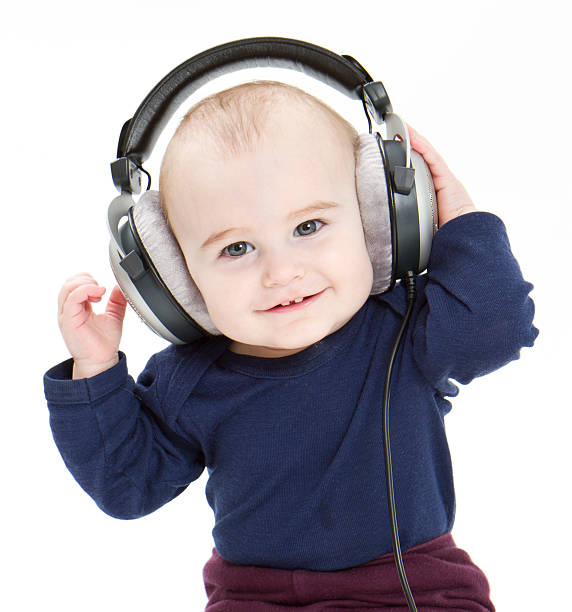 young child with ear-phones listening to music stock photo