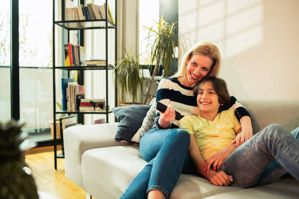 istock Mother and son relaxing on the sofa and watching TV 1743578966