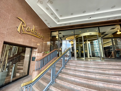 montevideo, uruguay - October 31 2022: sign of the american international hotel chain radisson in gold colored letters next to the entrance of a location