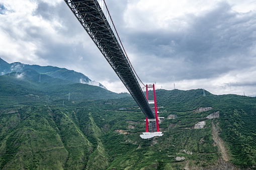 A bridge spanning between two mountains and a river