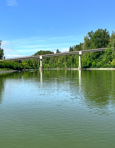 The bridge over Lake River is S. Ridgefield Wildlife Refuge road in Washington State. Picture taken from on the river. This channel merges with the Columbia River. Parts of the Ridgefield National Wildlife Refuge border the river. Is two pictures merged.