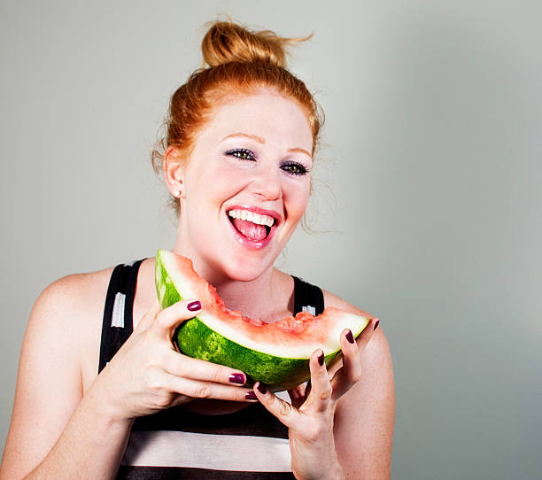 beautiful woman eating watermelon stock photo