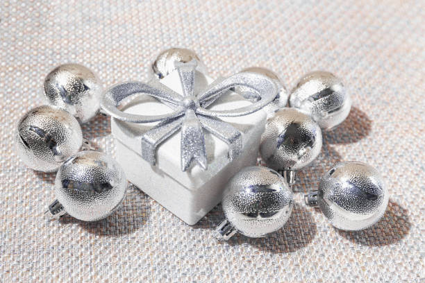 istock Creative composition made of silver present box and baubles on pastel background with shadows. Christmas and new year concept. Minimal style. 1743618591