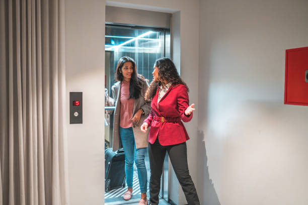 Attractive Young Woman Exiting the Elevator With Female Employee
