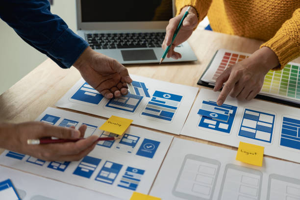 istock A team of web designers with the ux ui system are writing programs and layers to customize the appearance of the ux ui system and are working together to develop a mobile responsive website. 1743630540