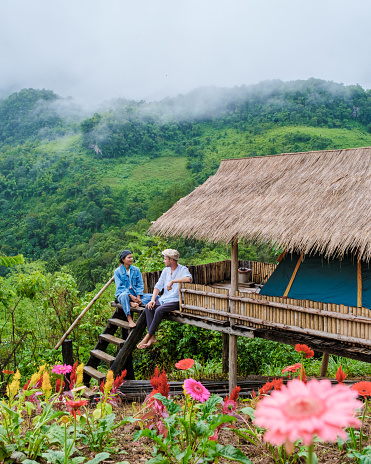 Doi Luang Chiang Dao mountain hills in Chiang Mai, Thailand.couple on a trip in the mountains camping during rain season with mist and fog at sunrise