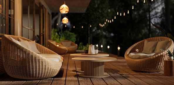 Side view of a beautiful deck with cosy round wicker armchairs, outdoor string lights and a beautiful nature view at night. Hotel or restaurant outdoor lounge. 3d render, 3d illustration