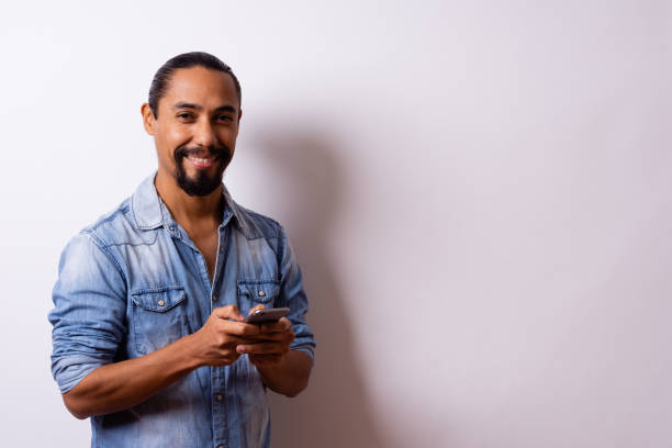 istock Man looking at camera with phone on white background. 1743696502