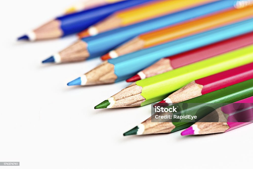 Pastelli matita multicolore in linea diagonale su bianco - Foto stock royalty-free di Affilato
