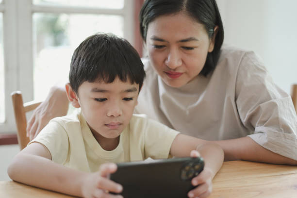 istock Child boy looking Mobile phone with mother 1743787328