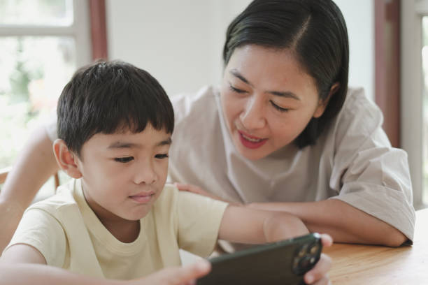 istock Child boy looking Mobile phone with mother 1743787840