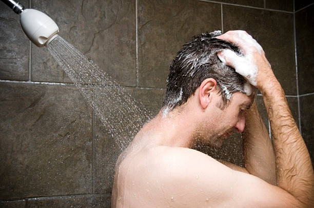 Man Showering, Water Washing Over Him stock photo