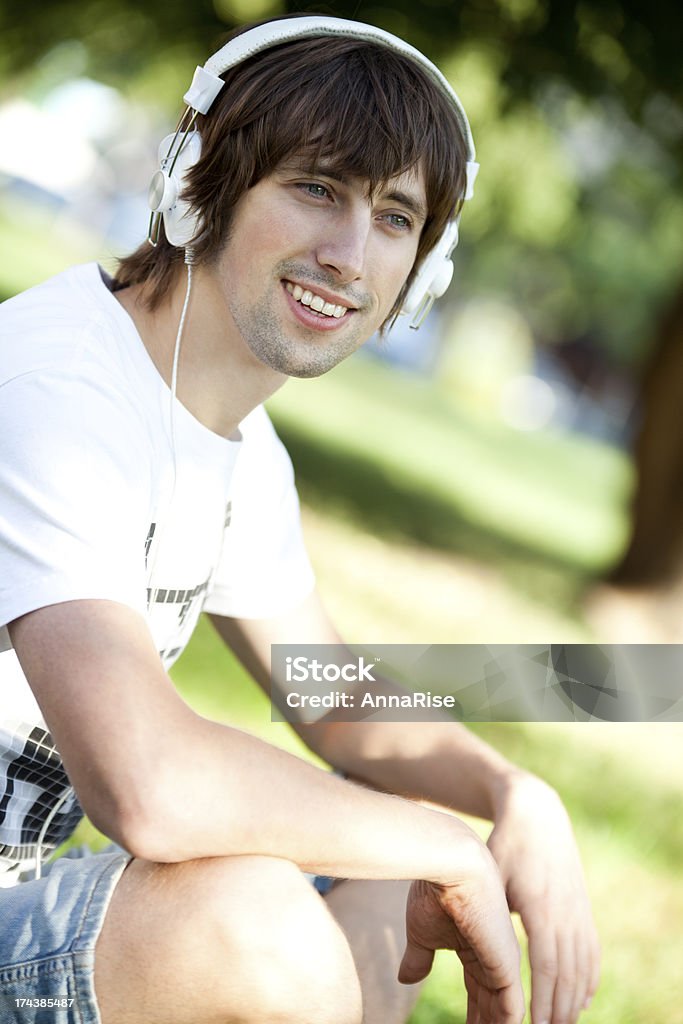 Jovem feliz homem desfrutando de música no parque - Foto de stock de 25-30 Anos royalty-free