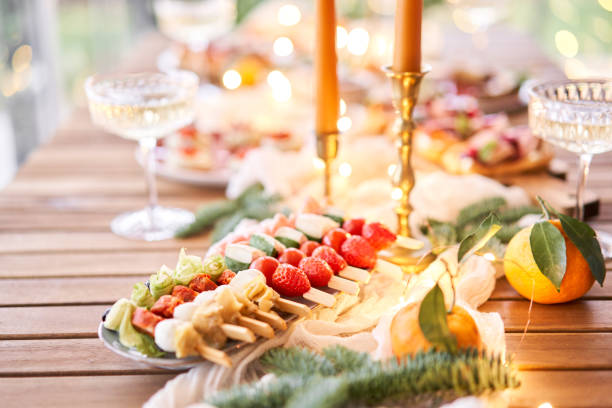 istock Christmas dinner feast. A small table is served with snacks, bruschettas, and canapes. A decorated dining table with champagne glasses, candles and christmas tree an garland in background 1743857848
