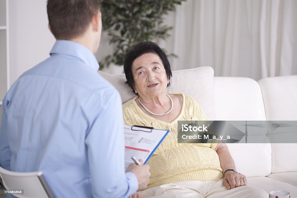 Donna anziana con un consulente. - Foto stock royalty-free di 70-79 anni
