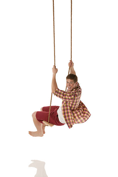 istock Happy man swinging on a rope swing 174386621