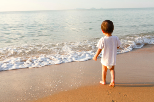 little boy playing in water on the beach