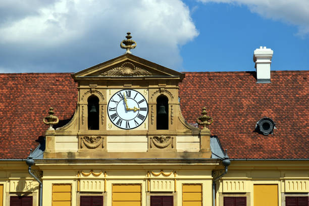 istock white round clock in decorative yellow brick exterior wall. yellow stucco exterior elevation. 1743889560