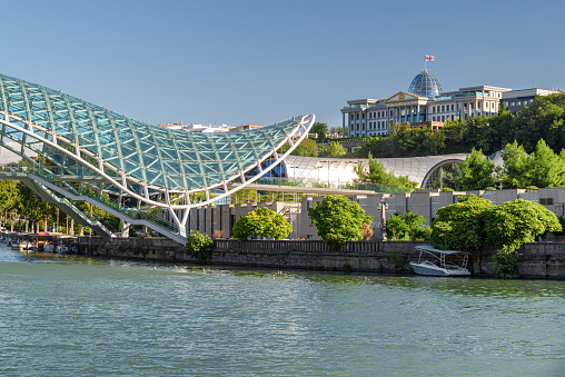 Scenic view of the Bridge of Peace over the Kura (Mtkvari) River and the Ceremonial Palace of Georgia (formerly Presidential Palace) in Tbilisi, Georgia.