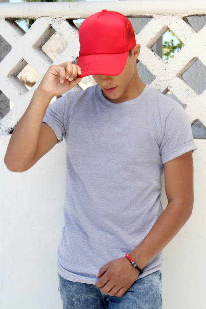 young man in gray t-shirt and red cap.