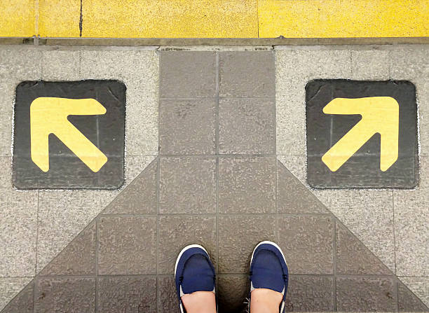 istock Two feet behind arrows in opposite directions 174394329