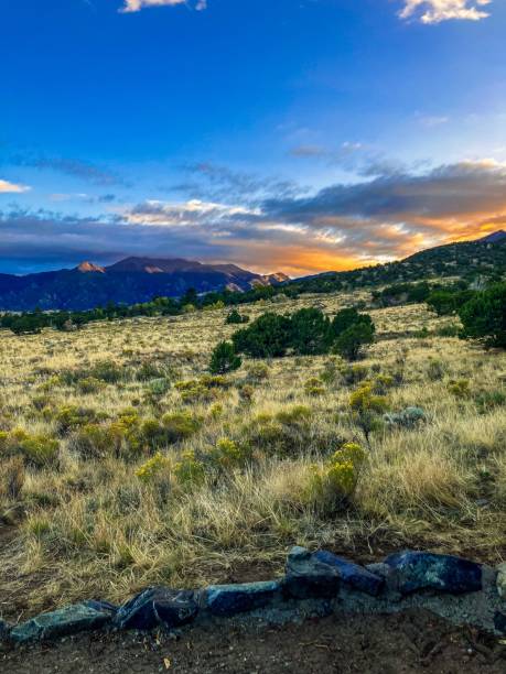 istock Dramatic sunset over a grassy valley, with a backdrop of lush mountains and shrubs 1743945335
