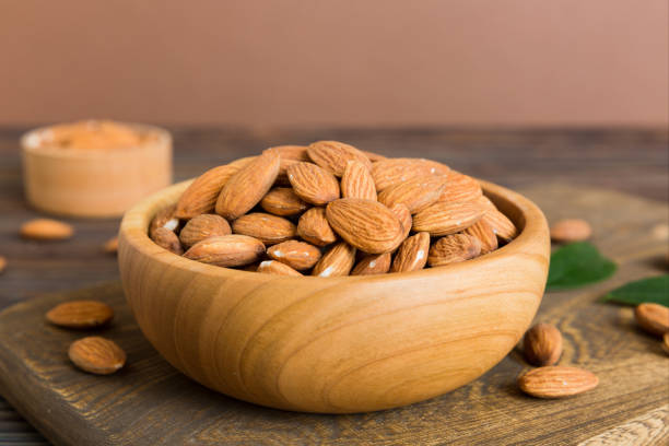 istock Fresh healthy Almond in bowl on colored table background. Top view 1743946450