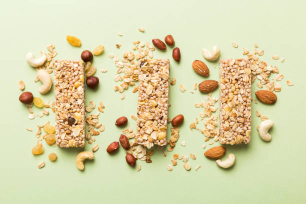 varias barras de granola sobre el fondo de la mesa. barras de granola de cereales. barritas de desayuno de superalimentos con avena, nueces y bayas, de cerca. concepto de superalimento - protein bar cereal oat cranberry fotografías e imágenes de stock