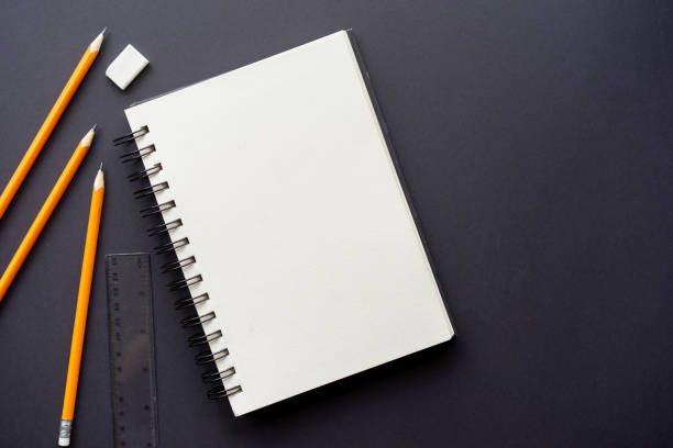 istock close up on white page notebook with school supplies and work tool on black background for back to school and flat lay design concept 1743947651