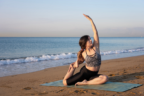 Yoga instructor performing asana poses, A yoga instructors practicing at the seaside