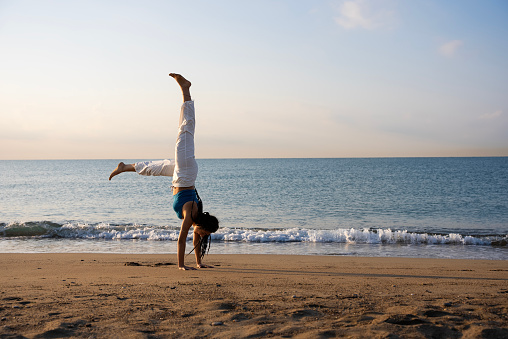 Yoga instructor performing asana poses, A yoga instructors practicing at the seaside