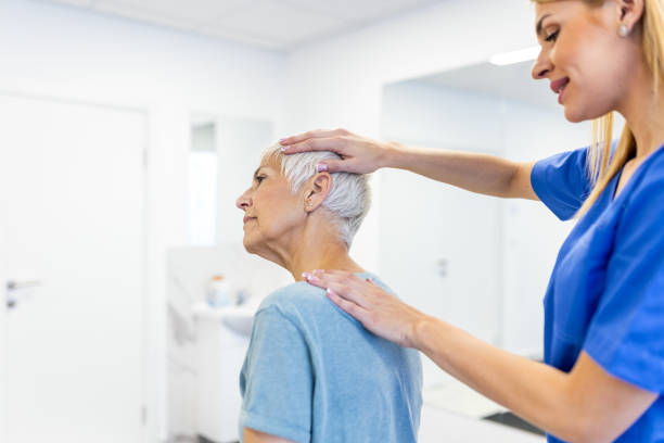 Licensed chiropractor or manual therapist doing neck stretch massage to relaxed female patient in clinic office. Young woman with whiplash or rheumatological problem getting professional doctor's help quiropráctico con licencia o terapeuta manual que realiza masajes de estiramiento del cuello a pacientes femeninas relajadas en el consultorio de la clínica. mujer joven con latigazo cervical o problema reumatológico que recibe ayuda de un médico profe