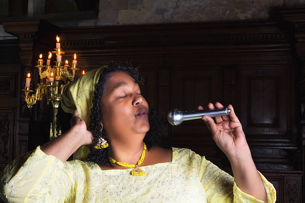 Gospel hymn Mature gospel singer with microphone singing during mass black female gospel singers stock pictures, royalty-free photos & images