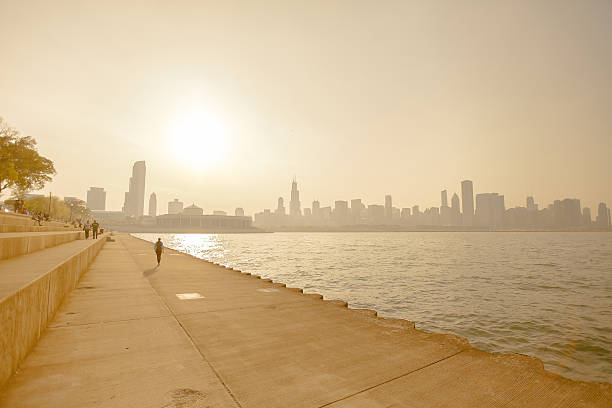 A heat wave and smog on the shoreline of a cityscape People walk along the lake near Chicago on a hot summer day heat wave photos stock pictures, royalty-free photos & images