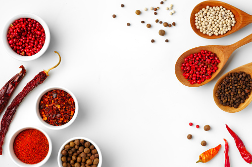 Indian spices background: top view of three bowls filled with cinnamon powder, paprika and turmeric shot on rustic wooden table. Cinnamon sticks, star anise, nutmeg, dried chili peppers and peppercorns are all around the bowl. Predominant colors are brown, red and yellow. High resolution 42Mp studio digital capture taken with SONY A7rII and Zeiss Batis 40mm F2.0 CF lens