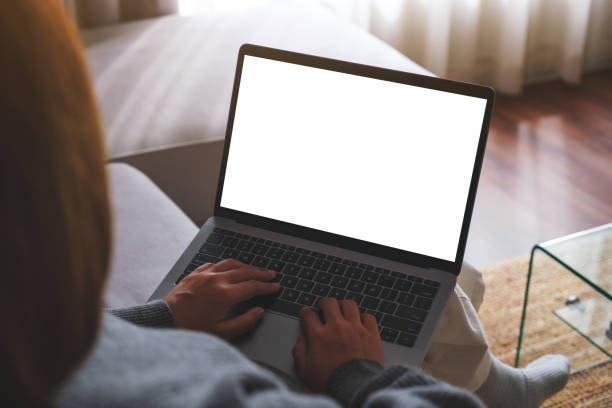 istock Mockup image of a woman working and typing on laptop computer with blank screen while sitting on sofa at home 1743995993